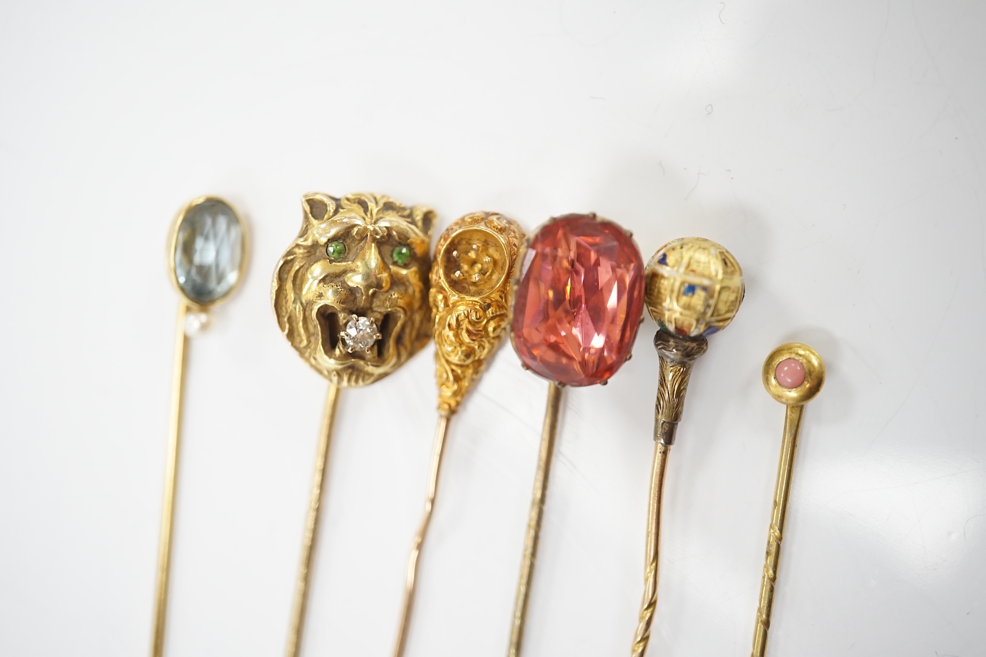 A collection of six assorted mainly early 20th century stick pins including tiger's head set with diamond and green garnets, 68mm. Condition - poor to fair